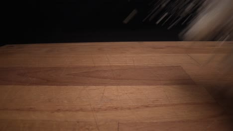 slow motion shot of chef throwing flour on chopping board