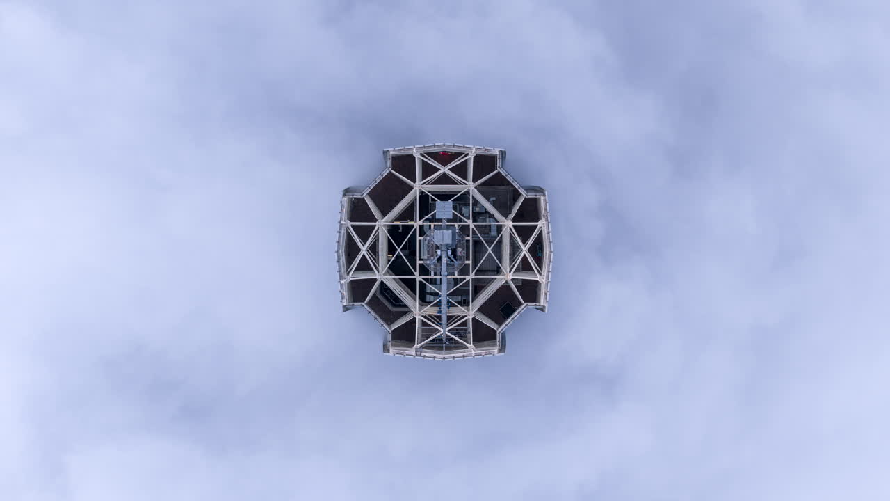 Hyperlapse with zenithal aerial view showing the top of Costanera Center surrounded by moving clouds in Santiago de Chile