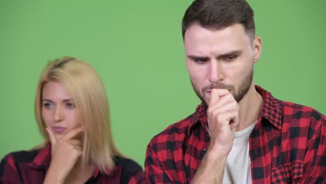 young couple thinking while looking down together