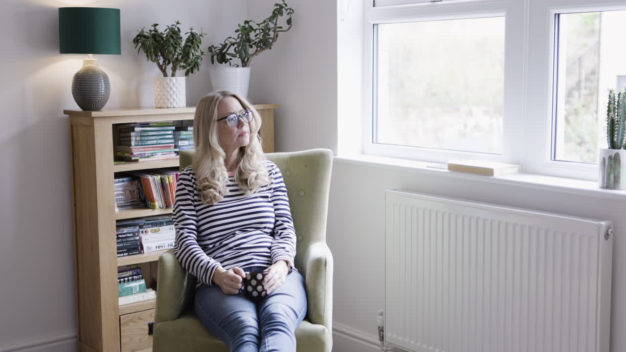 Femme se détendant dans un fauteuil avec une tasse