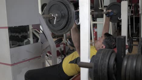 sportsman flexing chest muscles on bench