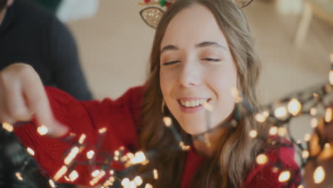 woman with glowing lights by friend during christmas