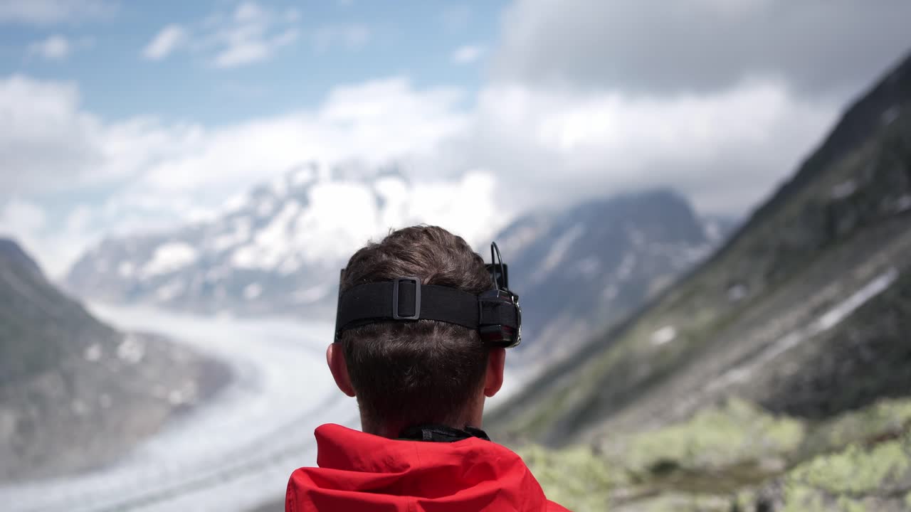 Man in red jacket with drone glasses overlooking Norway's mountainous landscape