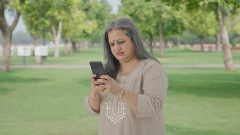 Angry-Indian-old-woman-chatting-on-phone-in-park