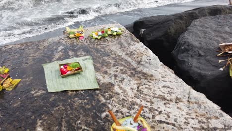 balinese flower offerings, canang sari at the beach, prayer and worship art in the bali sea, indonesia, hinduism, religious