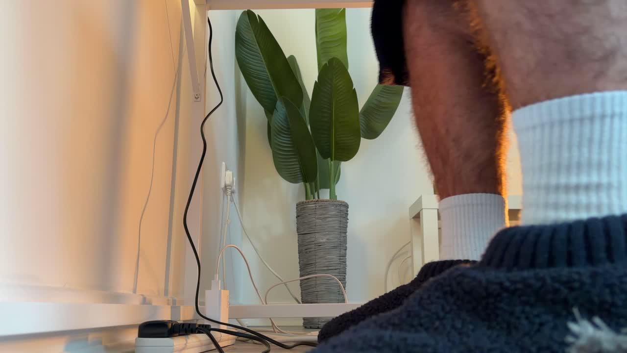 Feet Warming Under Desk with Slippers on Halogen Heater, Winter Home Office Heating, Cold Weather and Energy Cost-Saving Concept