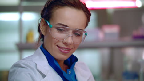 happy researcher in lab. lab resercher face in safety glasses. woman scientist