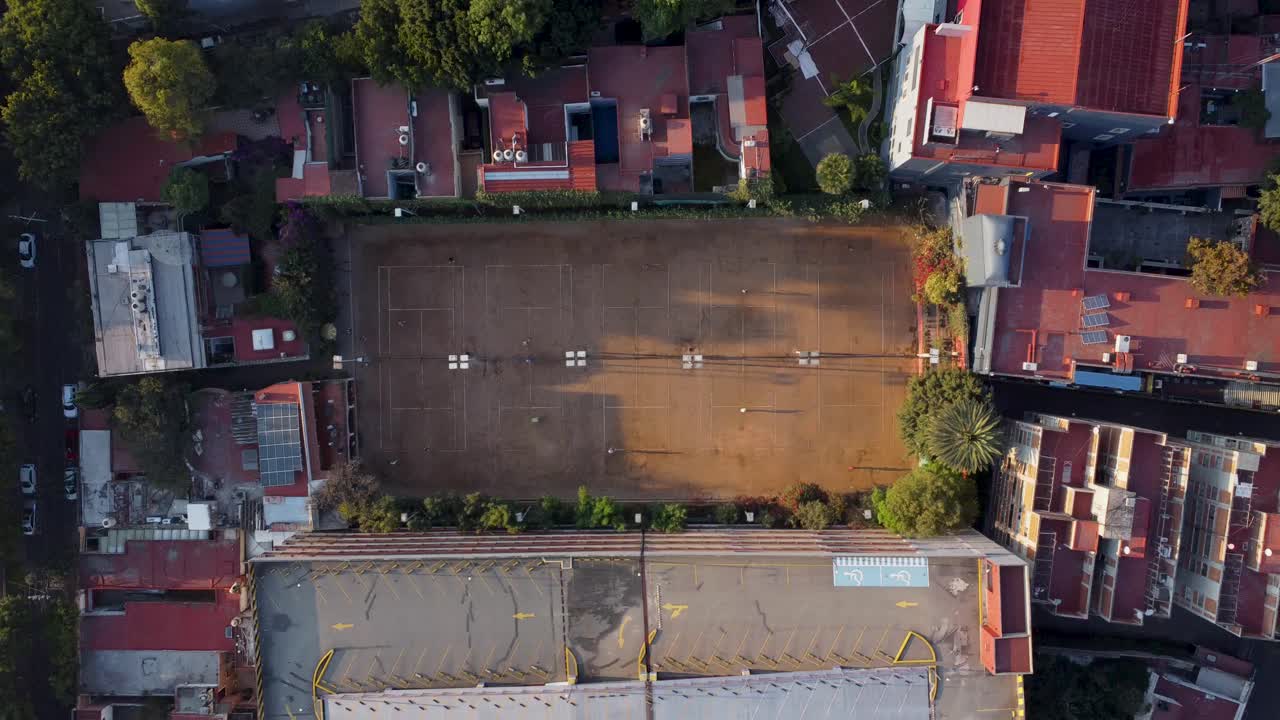 toma de arriba hacia abajo de cinco canchas de tenis de tierra batida y los alrededores en la mañana en la ciudad de méxico