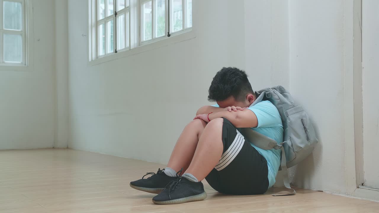 Asian Little Boy Sitting Alone With Sad Feeling At School. Bullying, Discrimination And Racism Concept