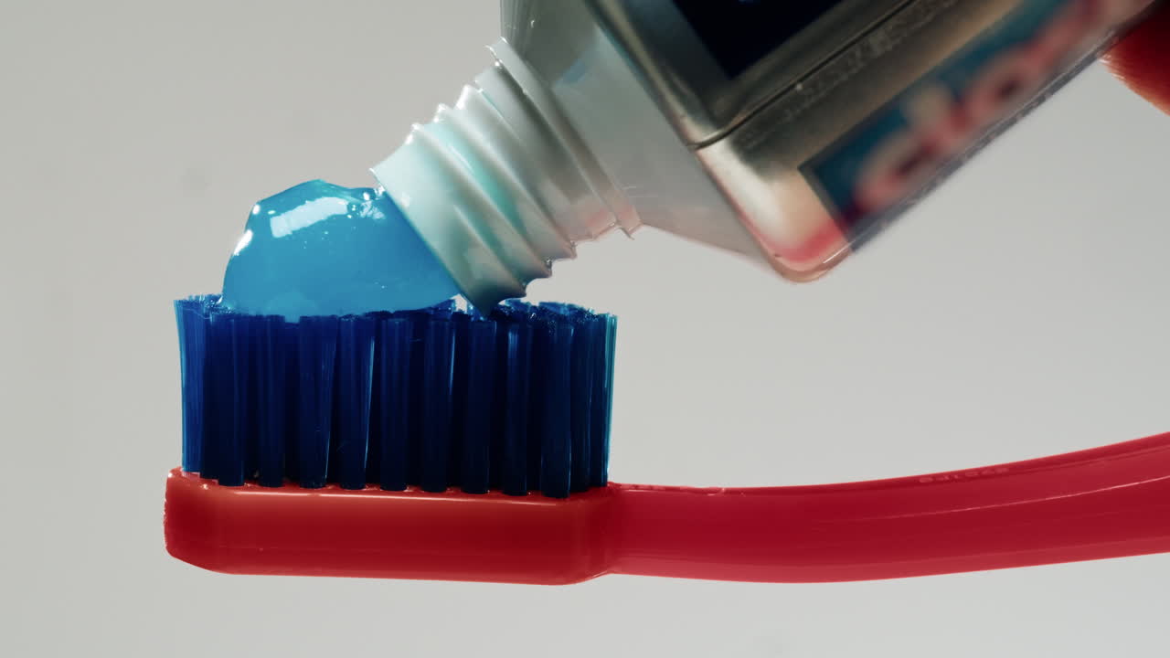 la aplicación de pasta de dientes a un cepillo de dientes