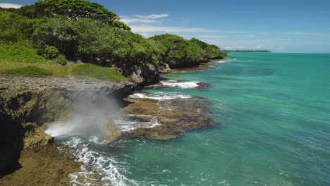 static shot of water spouting from small blowhole on isle of pines coast