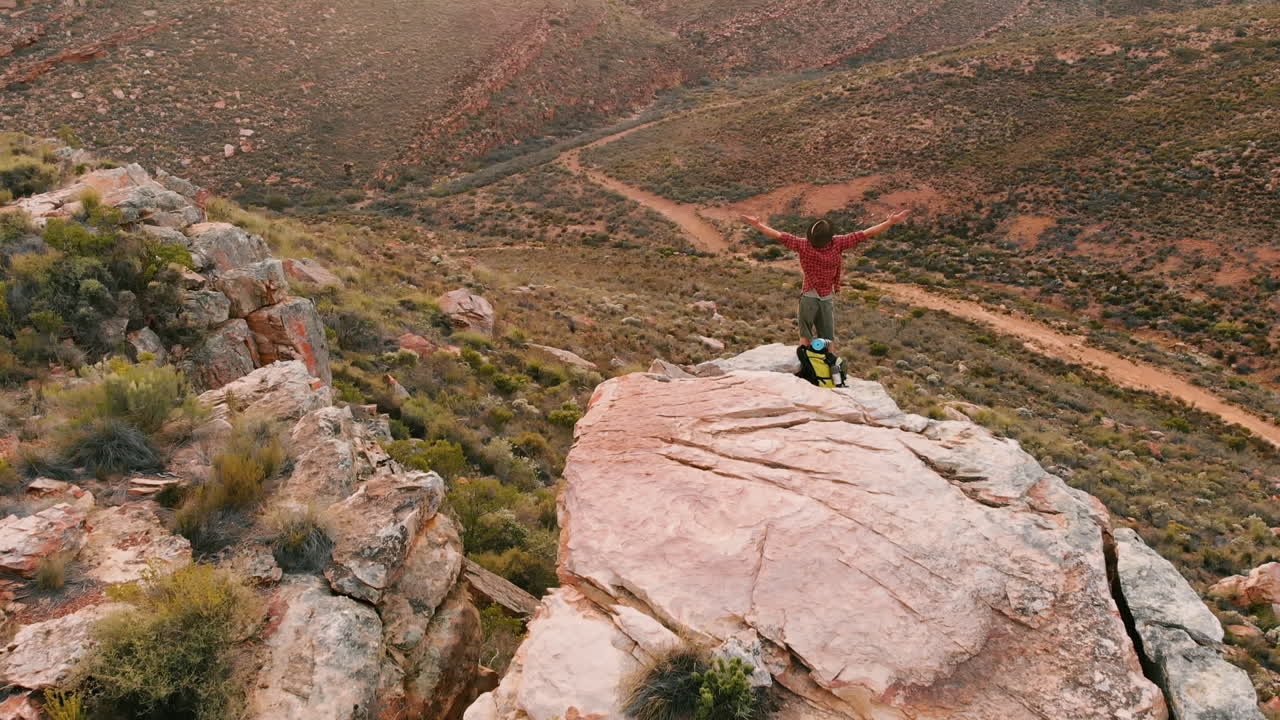 un hombre caucásico celebra en un pico de montaña, con espacio de copia