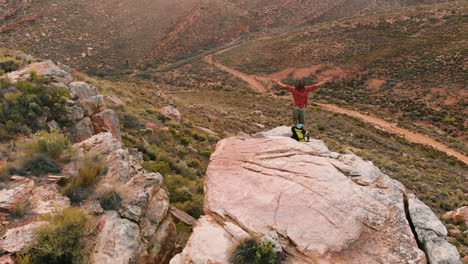 A-Caucasian-man-celebrates-on-a-mountain-peak,-with-copy-space