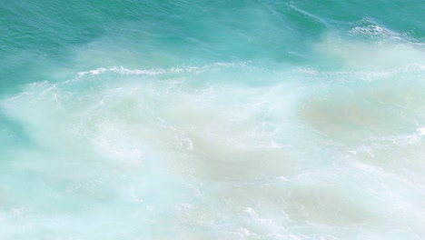 aerial view of rhythmic ocean waves meeting shore