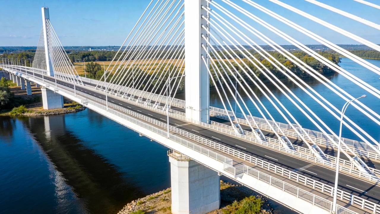 Starting drone sweeping cable-stayed bridge at river crossing, showing central pylon and cables