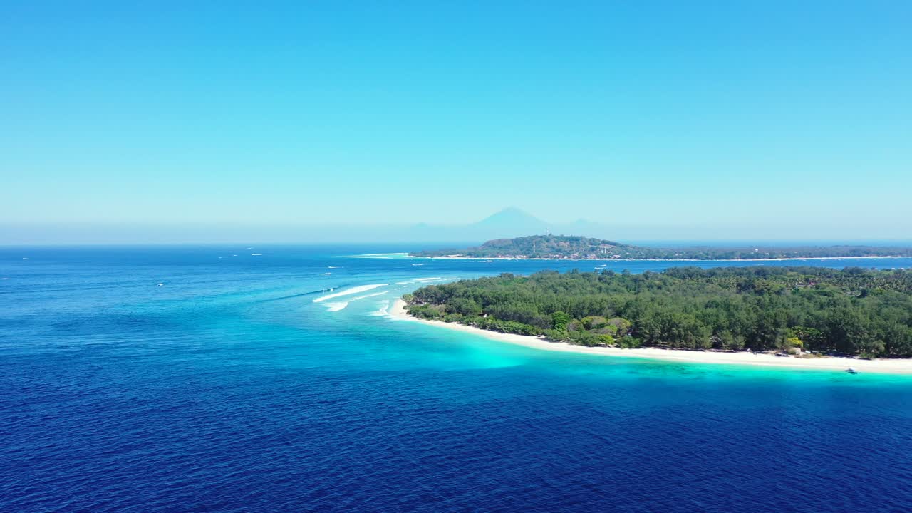 Vacations destination on tropical island with trees forest and white sandy beaches washed by blue azure sea water under clear bright sky in Gili, Indonesia