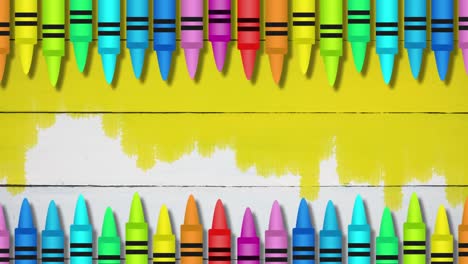 Multiple-colored-pencils-against-yellow-colored-wooden-background