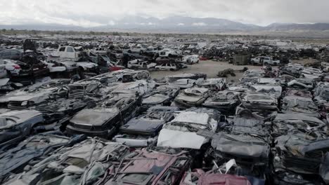 aerial of vast california desert junkyard with millions of cars in piles and rows