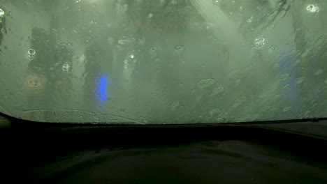rociador automático de agua de lavado de autos en el parabrisas espumoso 4k pov