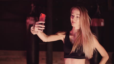 Attraktive-Sportlerin,-Die-Im-Fitnessstudio-Ein-Selfie-über-Das-Handy-Macht