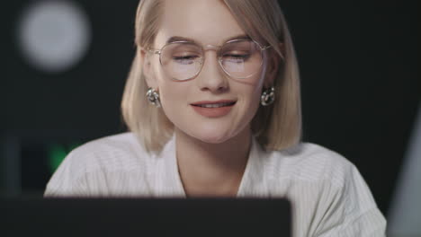 thinking business woman smiling front laptop in night office