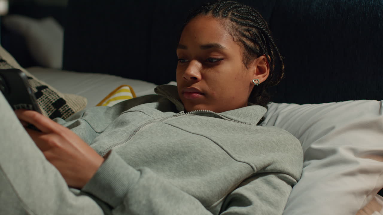 Teenage Girl Using Phone in Bed