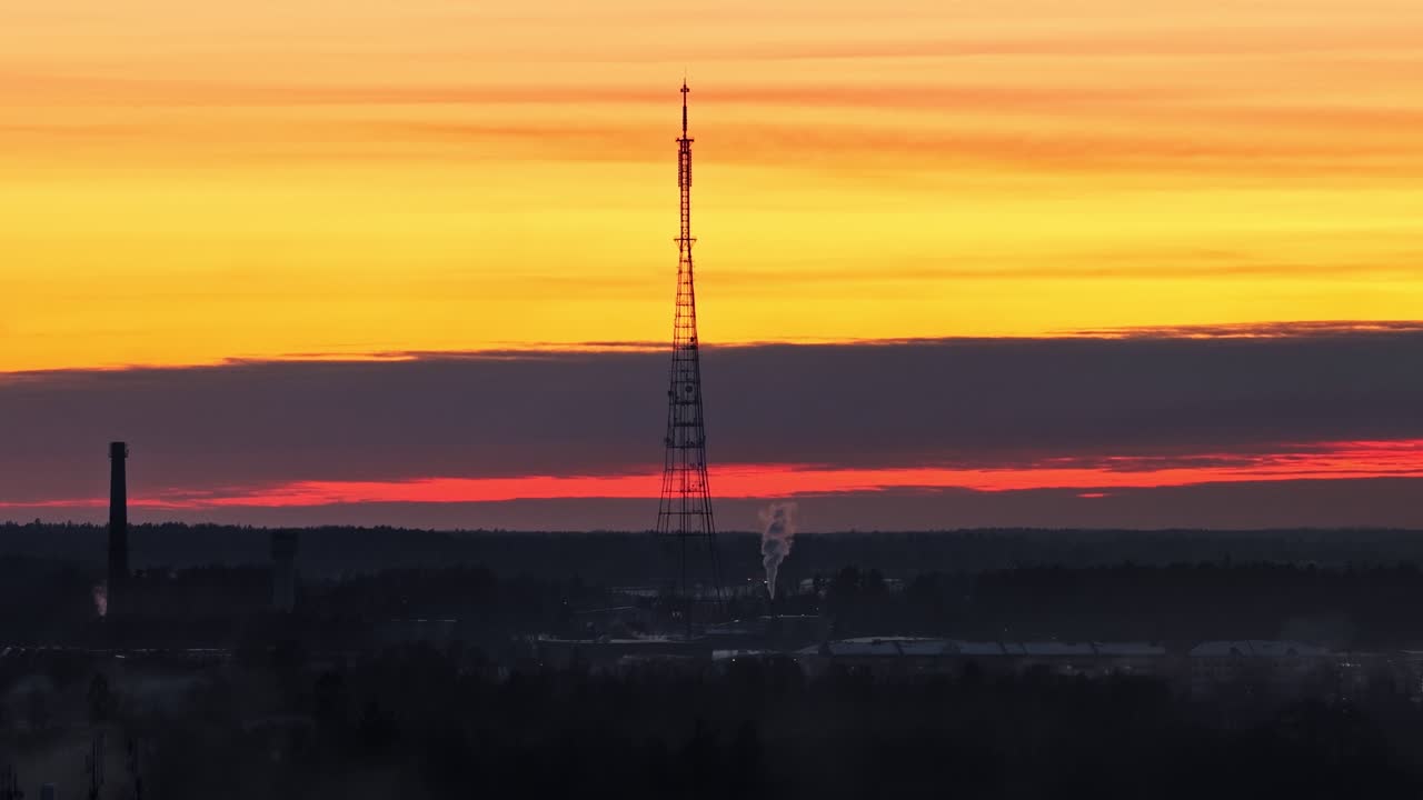 Skyline della città con torre di comunicazione contro un cielo serale al tramonto colorato