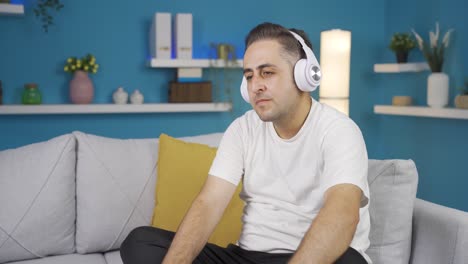 el hombre que escucha música con auriculares es infeliz y triste.