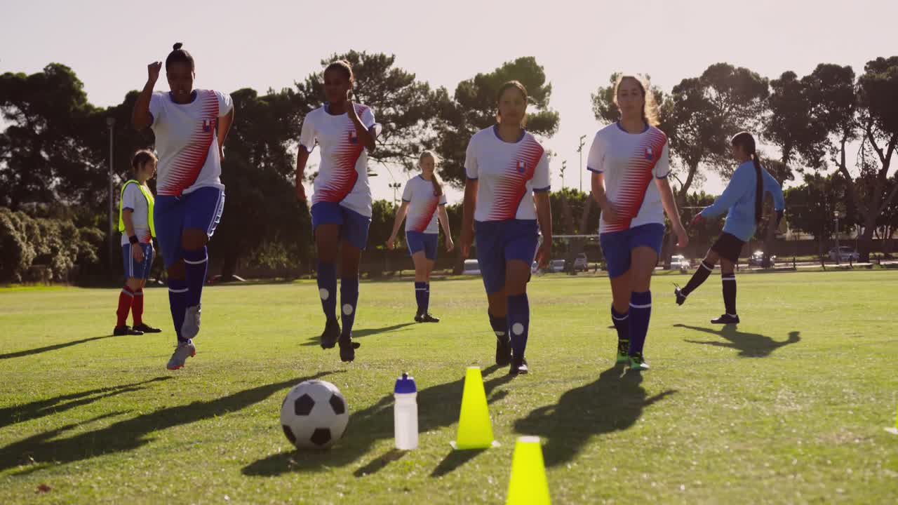 여자 축구 팀 이 축구장 에서 심장 운동 을 하고 있다. 4k