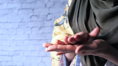 mujer con hijab con las manos