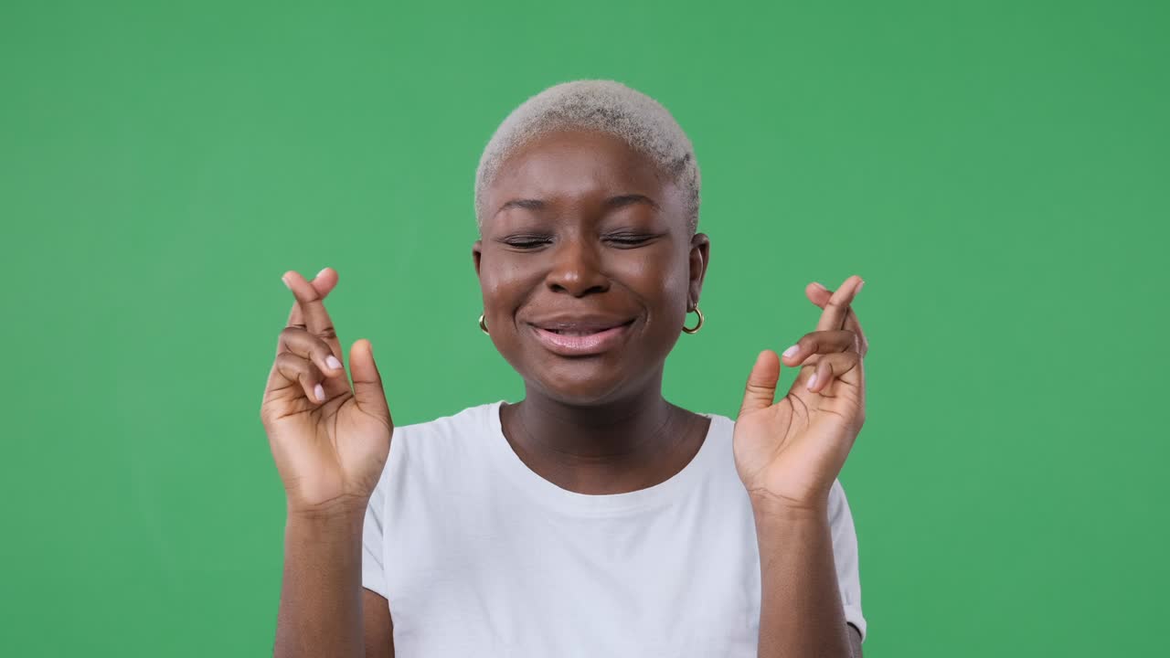 Excited woman wishing with fingers crossed