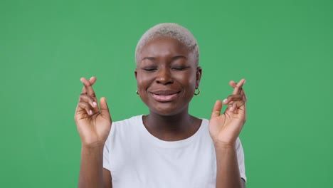 excited woman wishing with fingers crossed