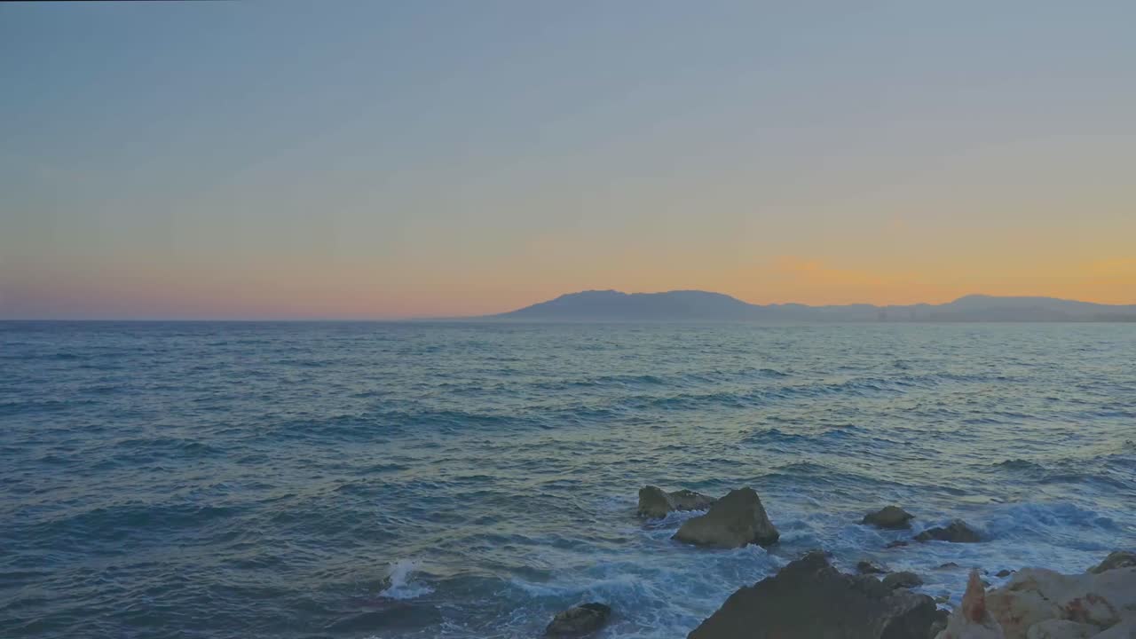 일몰 후 해안선을 강타하는 파도