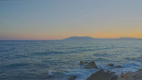 waves hitting the coastline after sundown