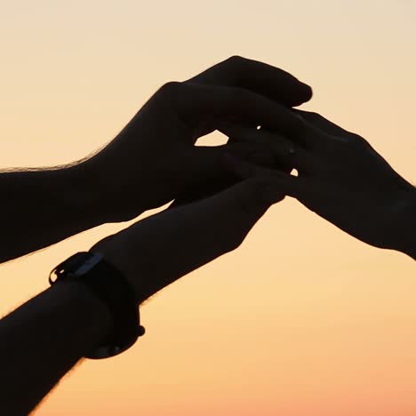 man putting ring on woman hand