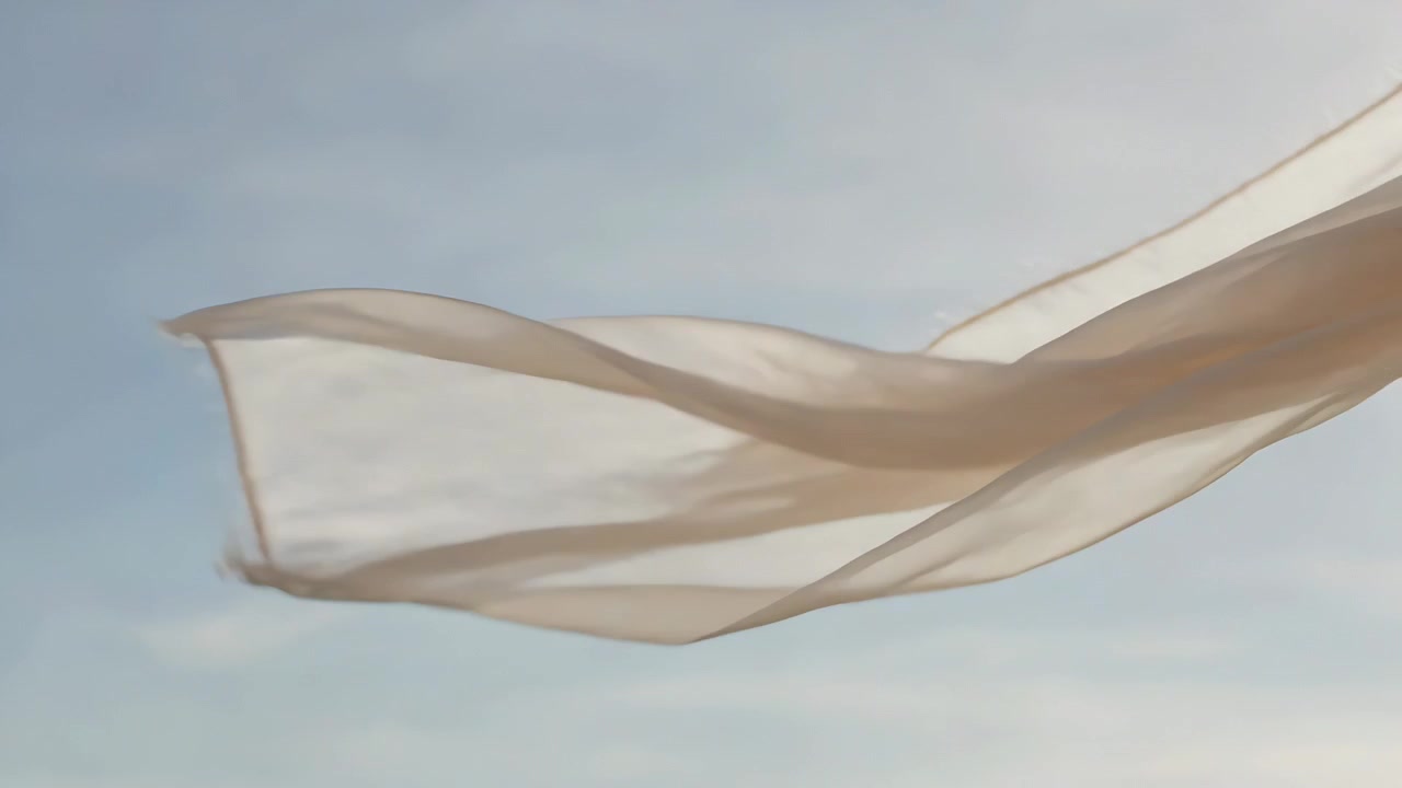 Billowing cream fabric rising with wind lifting it across open sky, backlighting hem and texture