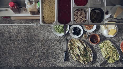 process of pizza preparation in restaurant kitchen