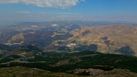 Vista-Aérea-Del-Establecimiento-Del-Hermoso-Paisaje-Con-Vistas-A-Las-Montañas,-Valles-Y-Edificios-Rurales-En-España,-Andalucía-En-Un-Soleado-Y-Cálido-Día-De-Verano.