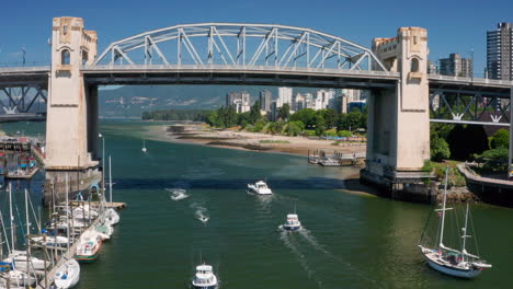 barcos navegando en false creek con el puente de la calle burrard cerca de sunset beach en canadá