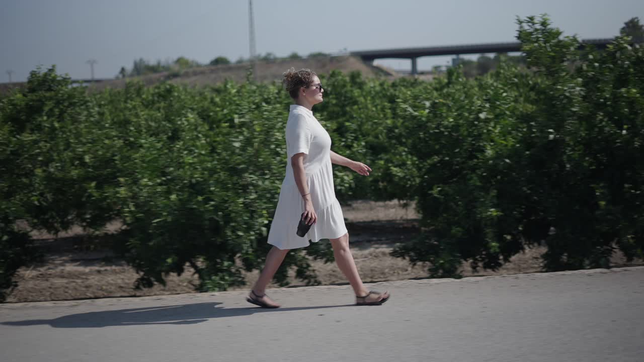 Woman walking in an orange grove