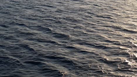 Paralaje-De-Drones-Alrededor-De-La-Luz-Del-Sol-Brillando-En-El-Océano-Abierto,-Aguas-Azul-Oscuro-Y-Profundo-En-El-Mar