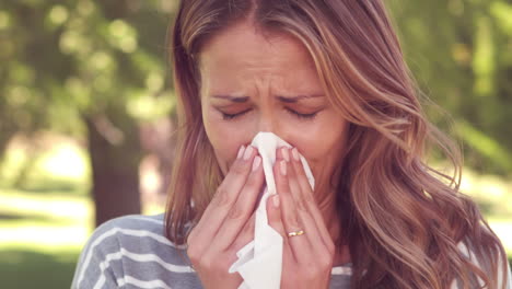 Pretty-woman-blowing-noses-into-tissues