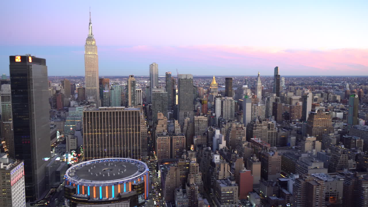 Panning aerial view of Empire State Buildings and Madison square garden. Sunset time gives stunning pink color to Manhattan