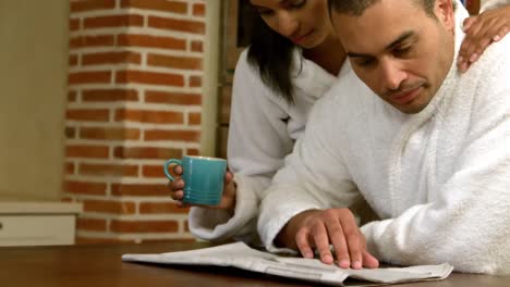 Couple-reading-newspaper-while-they-having-breakfast