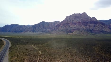 Aerial-of-dust-swirling-in-the-foreground-shot-in-Red-Rock-Canyon-area-outside-of-Las-Vegas-Nevada