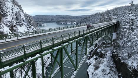 Tiro-Ascendente-Del-Puente-Del-Paso-Del-Engaño-Cubierto-De-Nieve-Con-Autos-Que-Lo-Cruzan