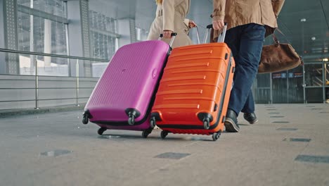 hurry to flight. two travellers late for flight, start running down airport terminal with luggage, close up of suitcases