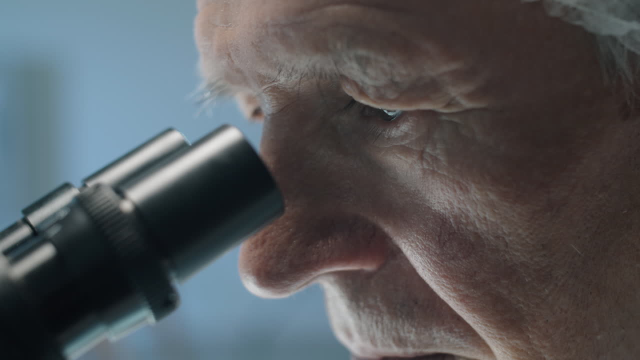 Scienziato Anziano che Guarda al Microscopio