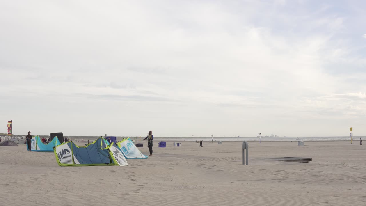 kitesurfista revisando su equipo en la playa de ijmuiden junto a amsterdam