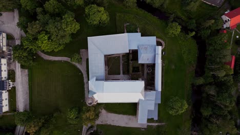 aerial drone footage of padise cistercian monastery presents an impressive medieval landmark in estonia with stone ruins and historic structures surrounded by fields and quiet natural scenery